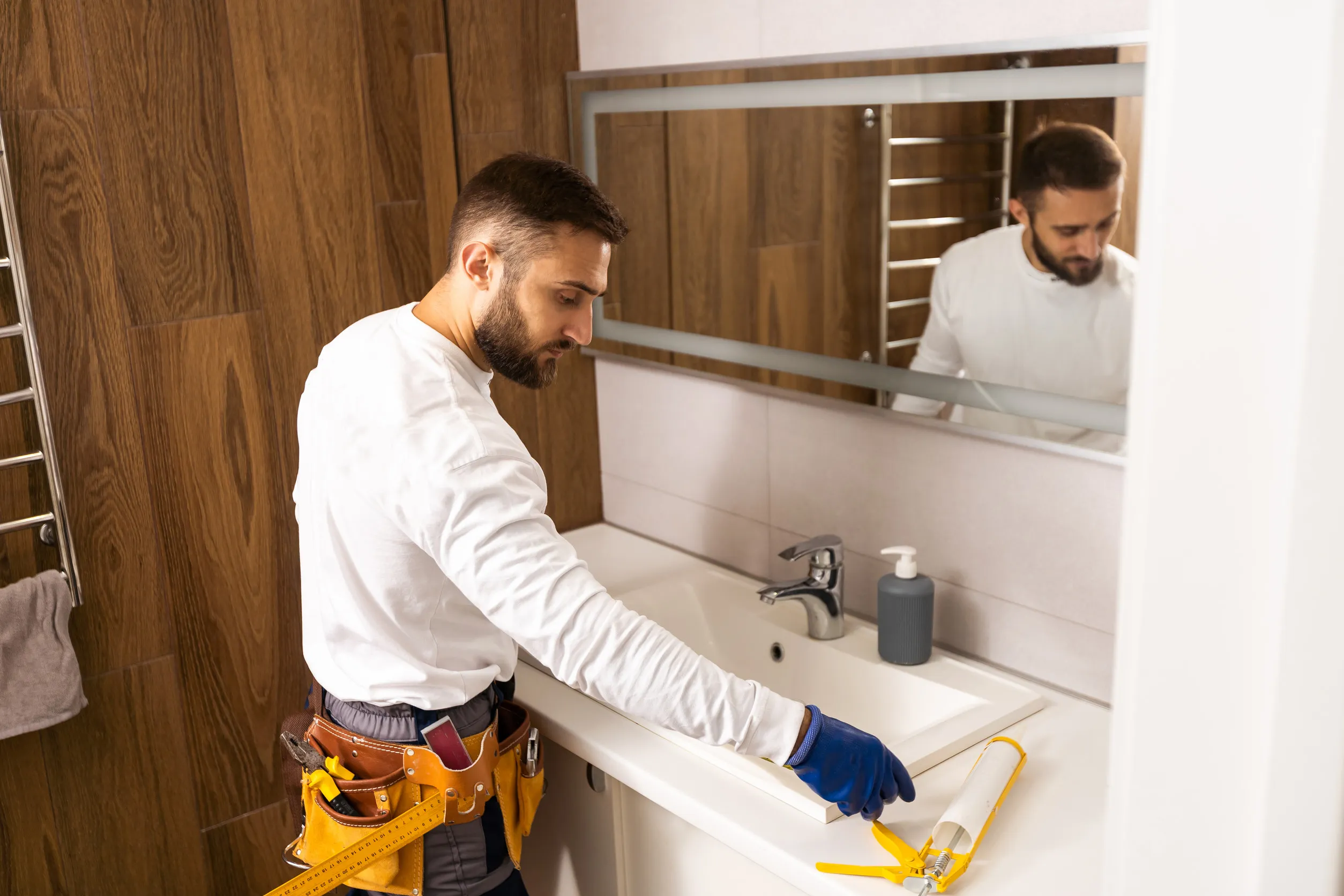 a worker installs a wash basin in a bathroom